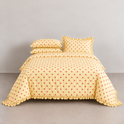 Isla Spot frilly cotton bedding in buttery yellow with pink polka dots