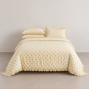 Isla Spot ruffle bedding in creamy yellow with powder blue spots