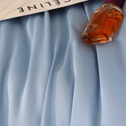 Close-up of pale blue silk fabric from the Agnes Silk Bedding Set, draped in soft folds with a sheen