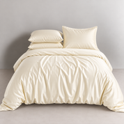 Agnes Silk Bedding Set in Ivory Luxe, made bed with softly draped silk and sheen catching the light