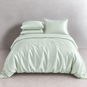 Agnes Silk Bedding Set in Mint Dream, made bed with silk quilt cover and pillowcases showing soft sheen