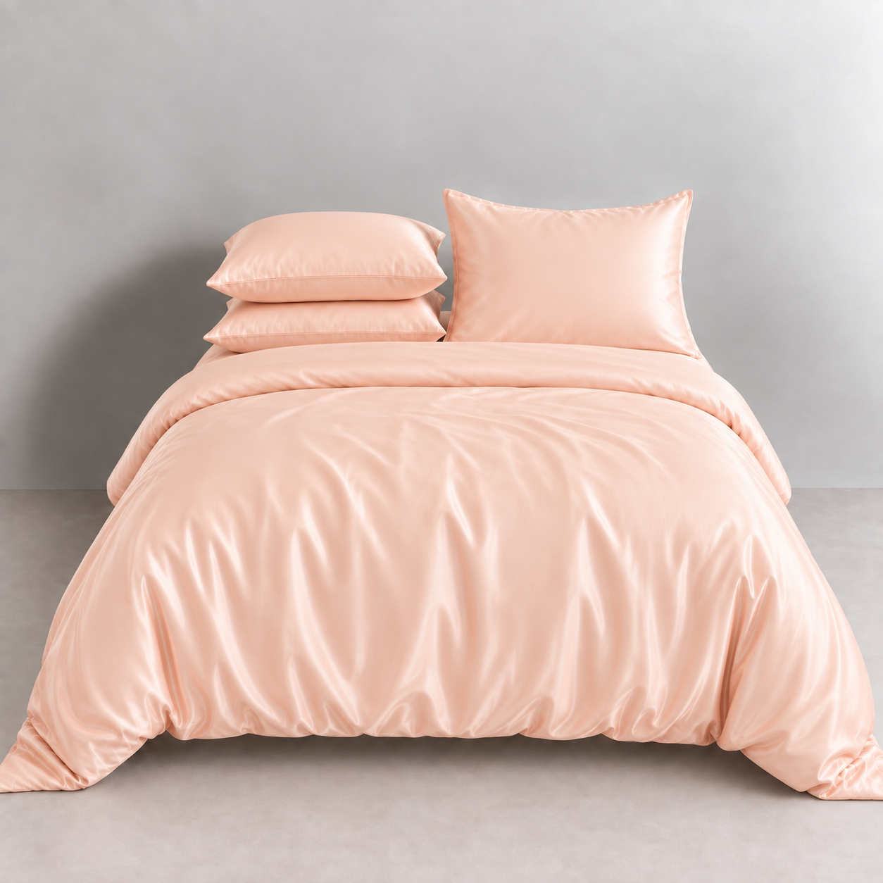 Agnes Silk Bedding Set in Peach Sorbet, made bed with glossy silk quilt cover and layered pillowcases