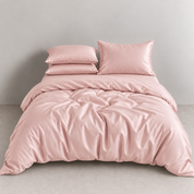 Amélie Bedding Set in Apricot Blush, glossy lyocell silk quilt cover rumpled softly on a made bed
