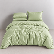 Amélie Bedding Set in Sage, sateen quilt cover with soft sheen styled on a bed with matching pillowcases
