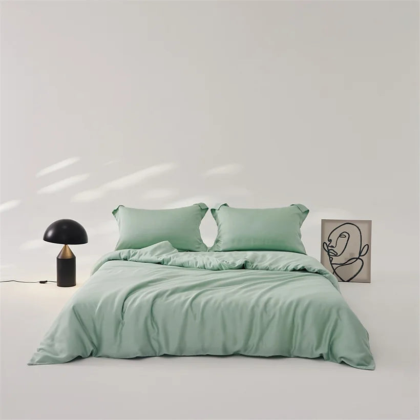 Amélie Bedding Set in soft sage green, styled on a bed with mushroom lamp and line-art print nearby