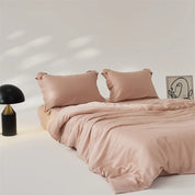 Amélie Bedding Set in soft dusty pink, draped over a bed with a mushroom lamp and line-art print nearby