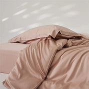 Amélie Bedding Set in dusty blush, lyocell silk quilt cover rumpled with soft sheen and light catching folds