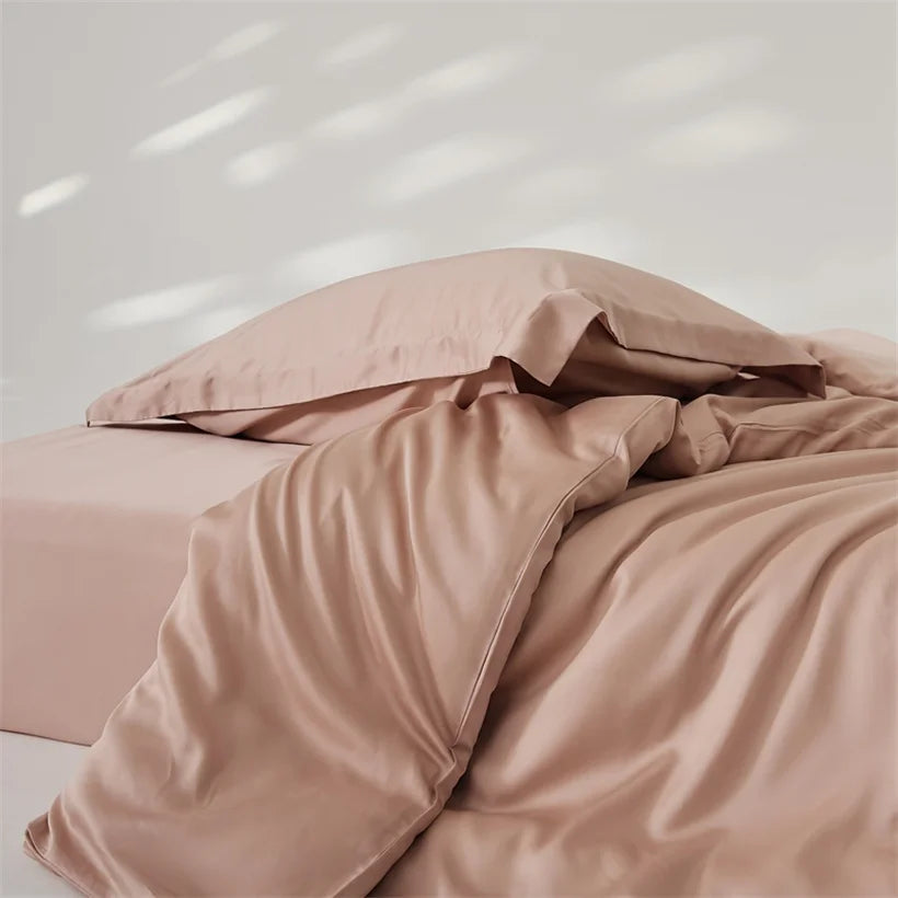 Amélie Bedding Set in dusty blush, lyocell silk quilt cover rumpled with soft sheen and light catching folds