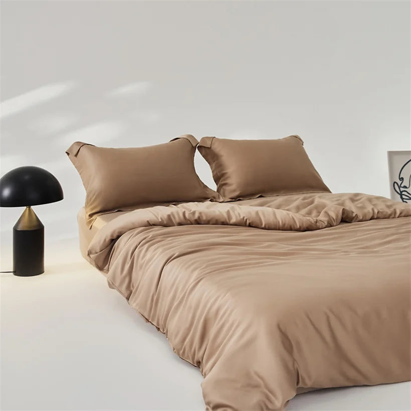 Amélie Bedding Set styled on a bed in warm sandstone tan, with a mushroom lamp beside it