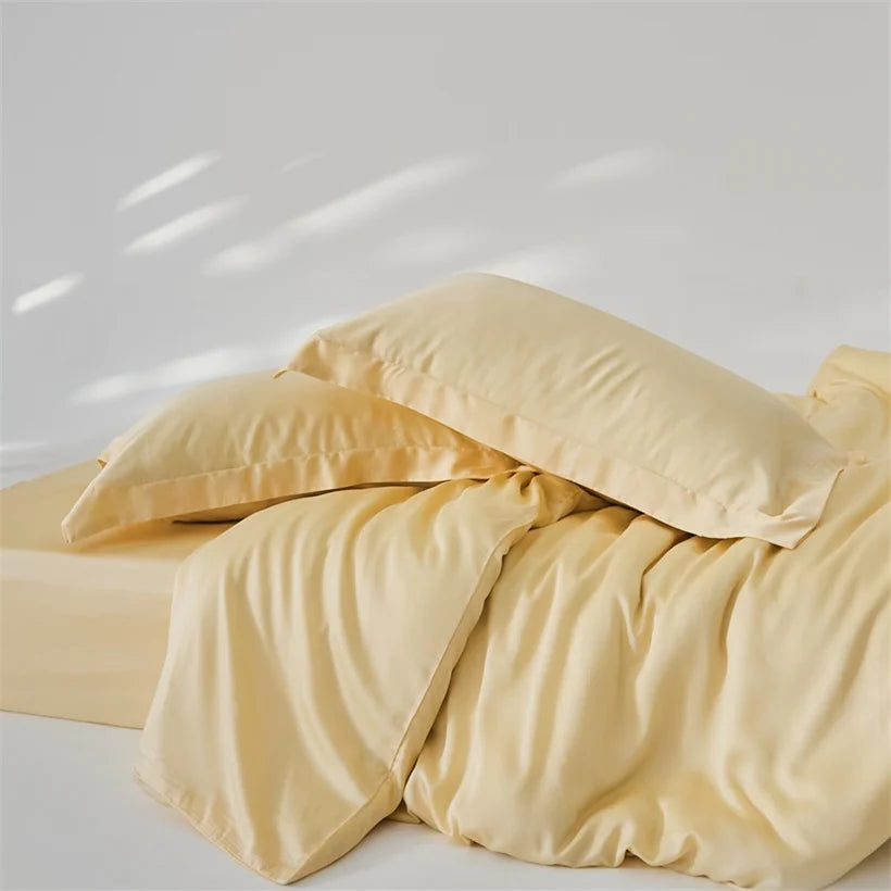 Amélie Bedding Set in golden yellow, quilt cover and pillowcases rumpled loosely on a bed, soft sheen