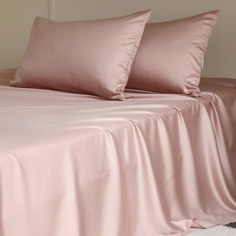 Amélie Flat Sheet Set in Petal Pink, made bed with soft sheen and draped folds of lyocell silk