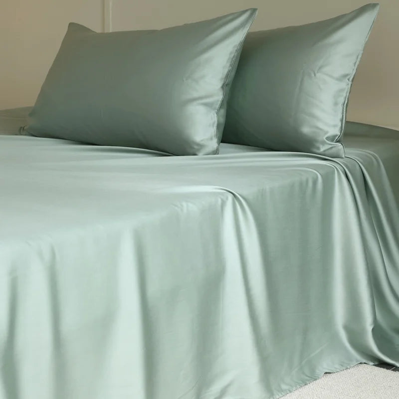 Amélie Flat Sheet Set in Sage Mist, sheeting and pillowcases with a soft lustrous sheen on a made bed