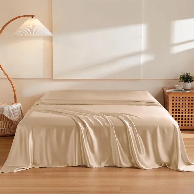 Amélie Flat Sheet Set in warm champagne, draped loosely over a bed with soft sheen and folds