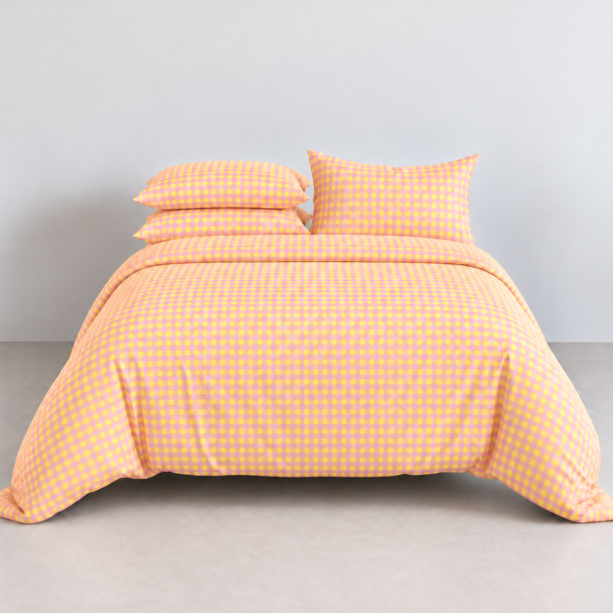 Avery Gingham Bedding Set in Mango Daiquiri, a bright orange and pink check on a made bed