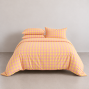 Avery Gingham Bedding Set in Peach Sorbet, made bed with yellow-pink check quilt cover and matching pillowcases
