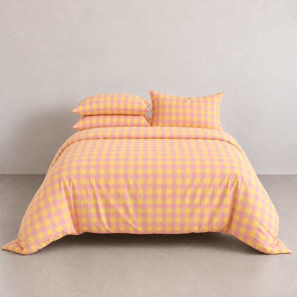 Avery Gingham Bedding Set in Peach Sorbet, made bed with yellow-pink check quilt cover and matching pillowcases