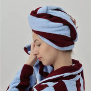 Woman wears Bambi Striped Bath Robe in Cherry Cola - Hair Turban, deep red and pale blue stripes on plush cotton