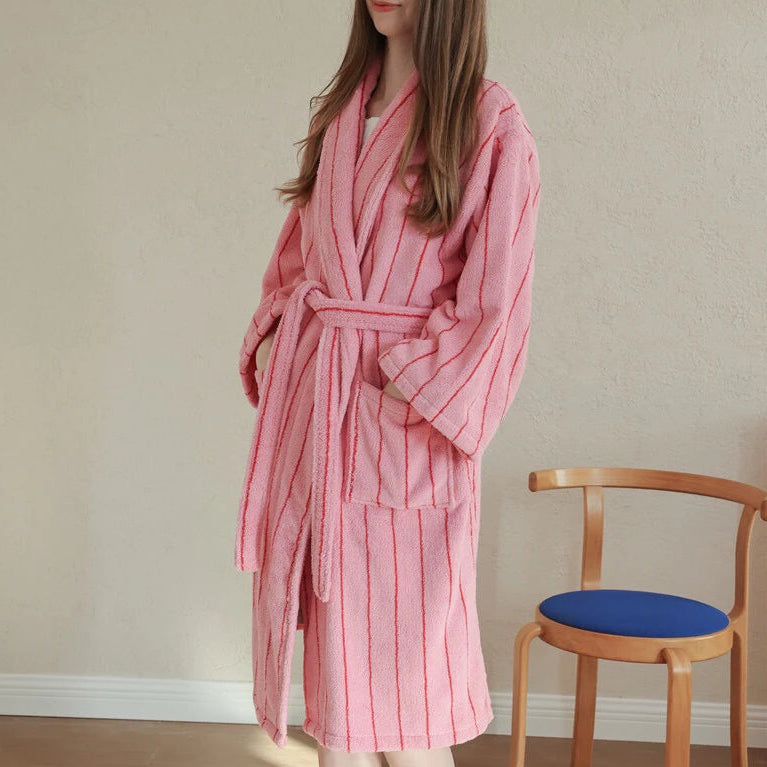 Bambi Striped Bath Robe worn belted in pink terry cotton with red stripes, beside a wooden chair