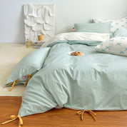 Blossom Bow Bedding Set in Mint, striped quilt cover with bow ties, styled on a bed with pastry plate
