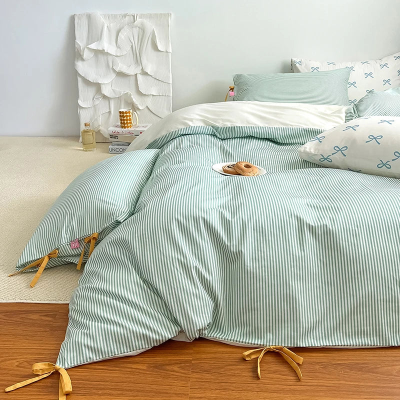 Blossom Bow Bedding Set in Mint, striped quilt cover with bow ties, styled on a bed with pastry plate