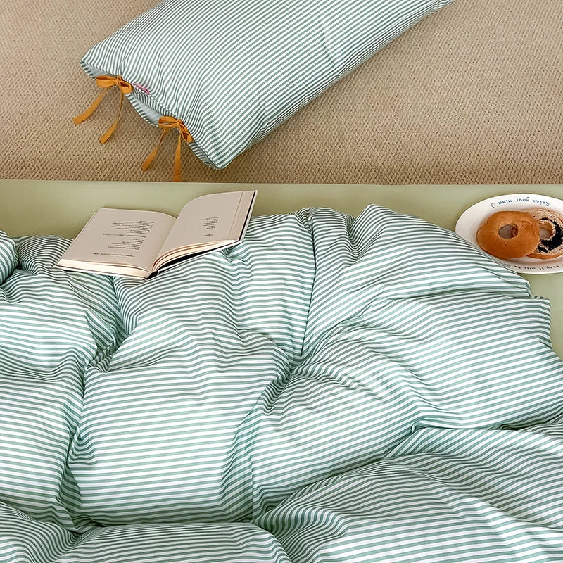 Blossom Bow Bedding Set in Mint, rumpled green striped quilt cover with an open book and bagels bedside
