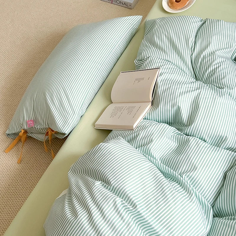 Blossom Bow Bedding Set in Mint, striped quilt cover with bow ties, open book resting on rumpled bed