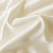 Close-up of the Camellia Ruffle Bedding Set fabric, soft ivory cotton blend gathered in smooth folds
