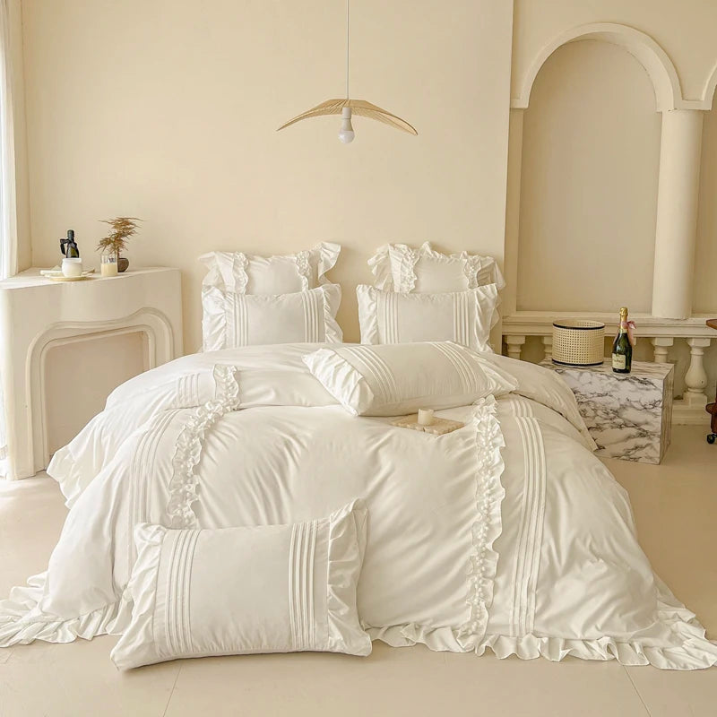 Camellia Ruffle Bedding Set in Ivory, styled on a made bed with ruffled pillowcases and pintuck cushions