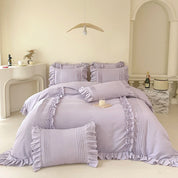 Camellia Ruffle Bedding Set in Lavender Mist styled on a made bed with ruffled pillowcases and pintuck detail