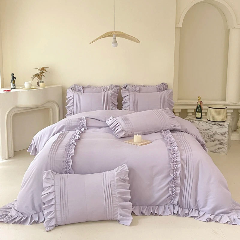 Camellia Ruffle Bedding Set in Lavender Mist styled on a made bed with ruffled pillowcases and pintuck detail