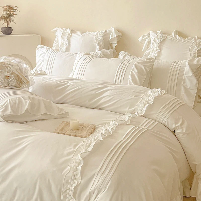 Camellia Ruffle Bedding Set styled on a bed, ivory cotton with ruffled trim and pintuck pillowcases