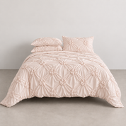 Camila Bedding Set in Blush, made bed showing rosette floral texture across quilt cover and pillowcases