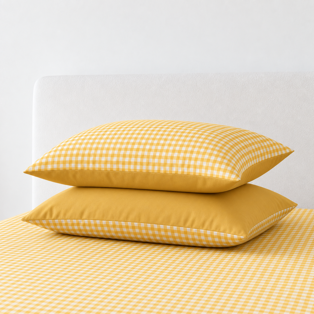 Two pillowcases from the Checkerboard Bedding Set in Lemon, gingham check with solid yellow reverse