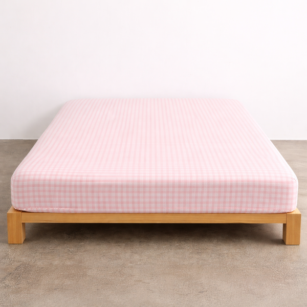 Checkerboard Fitted Sheet in Pink, soft check pattern fitted snugly over a mattress on a timber bed frame