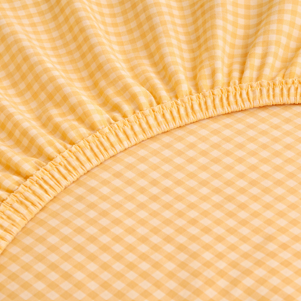 Close-up of the Checkerboard Fitted Sheet in Yellow, showing the elasticated edge and small check weave