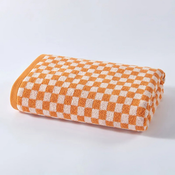 Checkerboard Towel Set in Orange, folded to show the jacquard check weave and terry texture