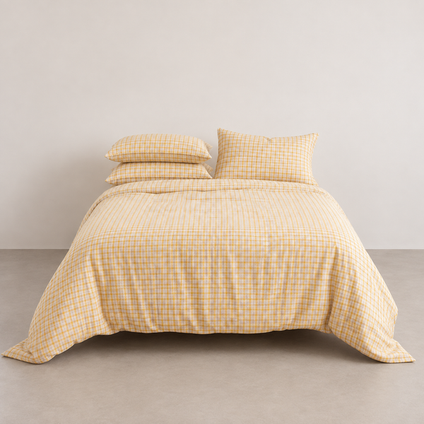Dakota Bedding Set in Butterscotch Plaid, a golden yellow check on a made bed against a plain wall
