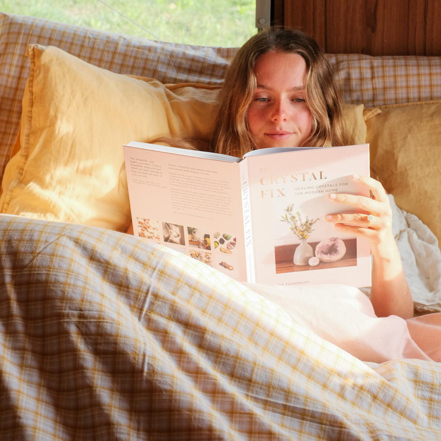 Woman reading in bed under the Dakota Bedding Set, mustard and cream plaid quilt cover and pillowcases