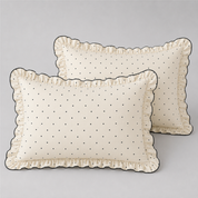 Two pillowcases from the Elsie Spot Bedding Set, ivory with fine black spots and a gathered scalloped frill edge