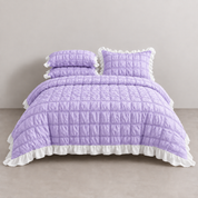 Esmé Ruffle Bedding Set in Lavender, made bed with quilted grid stitching and white frilled edge