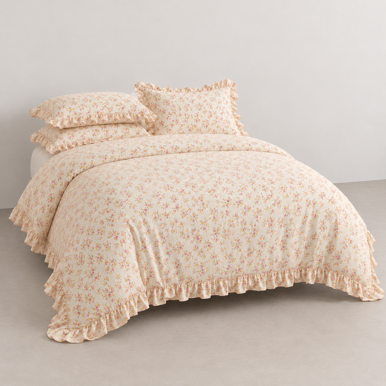 Honeybelle Floral Ruffle Bedding Set styled on a bed, cream cotton with pink and gold florals and ruffle edges