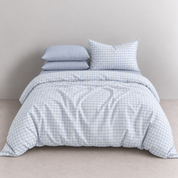 Honeythatch Gingham Bedding Set in Sky, pale blue check quilt cover with striped pillowcases on a made bed