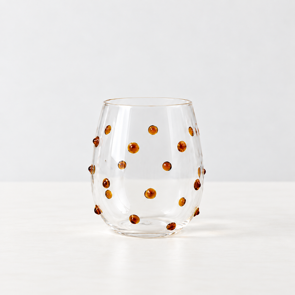 Isla Freckle Glass Tumbler in Yellow, clear stemless glass with raised amber dots scattered across the surface
