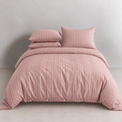 Juno Stripe Bedding Set in Dusty Plum, made bed with pinstripe quilt cover and stacked pillowcases, button closure detail