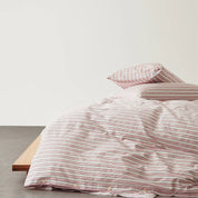 Juno Stripe Bedding Set in pink and white stripe cotton, made bed with button quilt cover closure