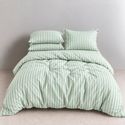 Juno Stripe Bedding Set in Sage, green striped quilt cover and pillowcases on a made bed