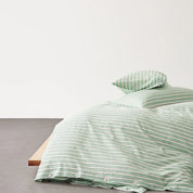 Juno Stripe Bedding Set in Sage, green and white stripes on a low bed with timber frame, button closure shown