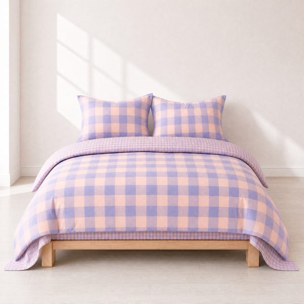 Kyoto Plaid Bedding Set in Lavender Haze, lilac and peach check on a made bed with wooden frame