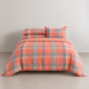 Kyoto Plaid Bedding Set in Tangerine Dream, coral check twill styled on a made bed with matching pillowcases