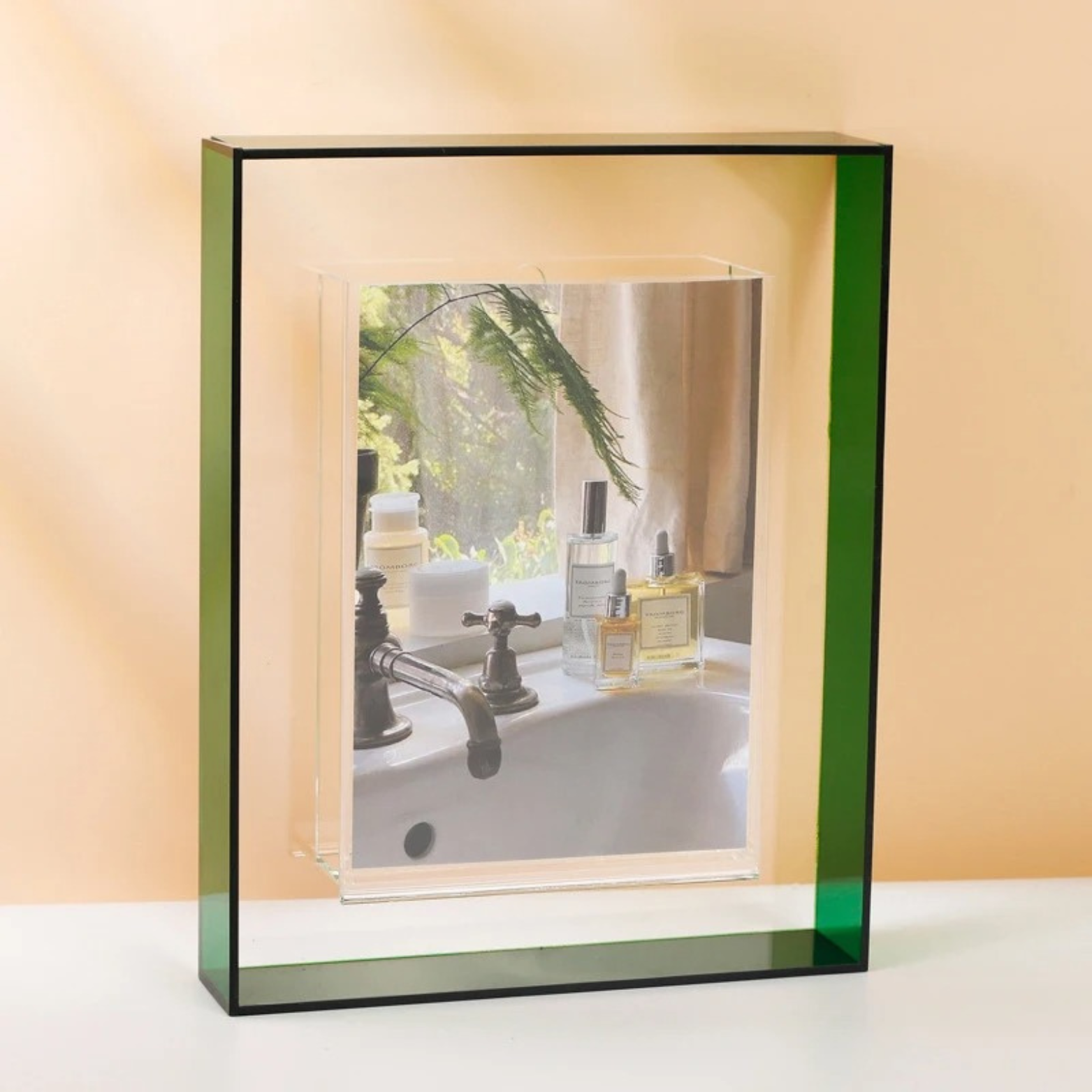 Lana Photo Frame in Forest Green, clear acrylic with a green edge, holding a bathroom scene photo on a tabletop